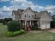Charming two-story home featuring a welcoming front porch, manicured lawn, and a two-car garage at 15211 Windward Ln, Lancaster, SC 29720