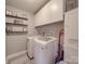 Functional laundry room with a washer, dryer, storage cabinets, and shelves for organizing laundry supplies at 15211 Windward Ln, Lancaster, SC 29720