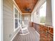 Covered front porch with rocking chairs, wood ceiling, and brick columns at 15211 Windward Ln, Lancaster, SC 29720