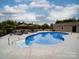 Inviting in-ground pool with lounge chairs and umbrellas surrounded by lush landscaping and a privacy fence at 15211 Windward Ln, Lancaster, SC 29720