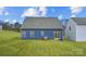 View of the home's backyard featuring manicured grass and the blue siding of the house at 1526 Cottage Creek Dr, Bessemer City, NC 28016