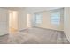 Cozy bedroom with soft gray carpet, two bright windows, and neutral-toned walls at 1526 Cottage Creek Dr, Bessemer City, NC 28016