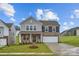 Charming two-story home featuring stone accents, a two-car garage, and a well-manicured lawn at 1526 Cottage Creek Dr, Bessemer City, NC 28016