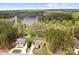 Aerial view of a gorgeous home near a lake surrounded by lush trees and greenery at 164 Crooked Branch Way, Troutman, NC 28166