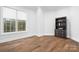 Bedroom with wood flooring, white walls, large window, and dark wood bookshelf at 164 Crooked Branch Way, Troutman, NC 28166