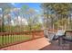 Wooden deck with outdoor dining set overlooking the backyard with mature trees at 164 Crooked Branch Way, Troutman, NC 28166
