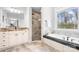 Luxurious main bathroom with a soaking tub, tiled shower, and double vanity sinks at 164 Crooked Branch Way, Troutman, NC 28166