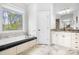 Bright main bathroom featuring a soaking tub, tiled floors, and double vanity sinks at 164 Crooked Branch Way, Troutman, NC 28166