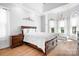 Elegant main bedroom featuring tray ceilings, hardwood floors, and a decorative chandelier at 164 Crooked Branch Way, Troutman, NC 28166