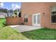 Cozy brick patio features white french doors and is surrounded by a well-maintained lawn at 164 Crooked Branch Way, Troutman, NC 28166