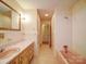 A classic bathroom featuring a floral wallpaper, vanity, toilet, and a tiled tub with shower at 167 Cedar Ln, Troutman, NC 28166