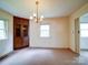 Bright dining room with a decorative chandelier, built-in wooden cabinets, and large windows at 167 Cedar Ln, Troutman, NC 28166