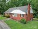 Charming brick home featuring a well-maintained lawn, mature trees, and black window shutters at 167 Cedar Ln, Troutman, NC 28166