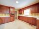 A classic kitchen featuring wooden cabinets, light countertops, and white walls with decorative wallpaper at 167 Cedar Ln, Troutman, NC 28166