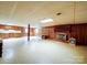 Large living room featuring wood paneling, a brick fireplace, and tile flooring offering a warm and inviting atmosphere at 167 Cedar Ln, Troutman, NC 28166