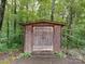 Rustic wooden outbuilding surrounded by lush greenery, provides additional storage space and blends seamlessly with the natural environment at 167 Cedar Ln, Troutman, NC 28166