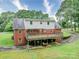 Expansive two-story home features a large wooden deck overlooking the lush backyard, ideal for outdoor entertaining at 167 Cedar Ln, Troutman, NC 28166