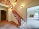 Wooden staircase featuring carpeted steps, a wooden railing, and decorative light fixtures at 167 Cedar Ln, Troutman, NC 28166