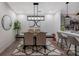 Dining area featuring modern lighting fixtures, comfortable seating, and an open view to the kitchen and breakfast bar at 17143 Red Feather Dr, Charlotte, NC 28277