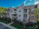 Attractive condominium building showcasing light siding, brick accents, and private balconies with white railings at 17143 Red Feather Dr, Charlotte, NC 28277
