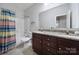 Bathroom features a double sink vanity with granite countertops and a tub and shower combination with a colorful curtain at 1718 Still River Way, Fort Mill, SC 29708