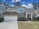 Charming two-story home with stone accents, a two-car garage, and a well-maintained front yard at 1718 Still River Way, Fort Mill, SC 29708