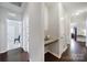 A hallway with hardwood floors features a small granite topped desk, and views into the kitchen and bathroom at 1718 Still River Way, Fort Mill, SC 29708