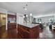 Open kitchen with a granite island, wood cabinets, and hardwood floors, flowing into the living area at 1718 Still River Way, Fort Mill, SC 29708