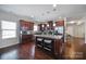 Open kitchen with dark wood cabinets, stainless appliances, granite counters, and pendant lighting over island at 1718 Still River Way, Fort Mill, SC 29708