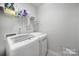 Laundry room features side-by-side washer and dryer, shelving above, and neutral paint at 1718 Still River Way, Fort Mill, SC 29708