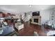 Open-concept living area with hardwood floors, a stone fireplace, and an adjacent kitchen and staircase at 1718 Still River Way, Fort Mill, SC 29708