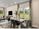 Sunlit dining area featuring views of the backyard, stylish decor, and hardwood floors at 1726 Braemar Village Dr, Monroe, NC 28110