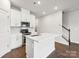 Well-lit kitchen featuring a central island, stainless steel appliances, and stylish backsplash at 1743 Braemar Village Dr, Monroe, NC 28110