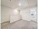 Open loft area with neutral walls and plush carpeting, providing a flexible space for relaxation or entertainment at 1743 Braemar Village Dr, Monroe, NC 28110