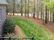 Beautifully landscaped backyard with lush lawn and mature trees, complemented by a tidy flower bed at 1849 Oakmont Dr, Denver, NC 28037