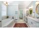 Bright bathroom featuring double vanities, garden tub, and walk-in closet access at 1849 Oakmont Dr, Denver, NC 28037