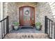 Elegant front entrance features a beautiful wood door with glass detailing, enhanced by decorative plants at 1849 Oakmont Dr, Denver, NC 28037