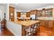 Kitchen view showcasing granite countertops, wooden cabinets, an island with seating, and stainless steel refrigerator at 1849 Oakmont Dr, Denver, NC 28037