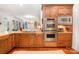 A kitchen featuring wood cabinets, granite countertops, and stainless steel double oven appliances in an open floor plan at 1849 Oakmont Dr, Denver, NC 28037