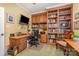 Office features built in shelves and wood desk with comfortable seating at 1849 Oakmont Dr, Denver, NC 28037