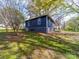 Exterior view of a blue home highlighting a nicely landscaped backyard at 1903 Marshall Ave, Gastonia, NC 28052