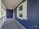 Side view of the cozy front porch with gray wood floor and classic white railings at 1903 Marshall Ave, Gastonia, NC 28052