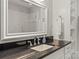 Elegant bathroom featuring a dark granite countertop, framed mirror, and glass shower with white tiled walls at 19040 Mary Ardrey Cir, Cornelius, NC 28031