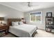 Comfortable bedroom showcasing a woven headboard, matching side tables, and a large window with tree-filled backyard views at 19040 Mary Ardrey Cir, Cornelius, NC 28031