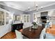 Elegant dining room with a large table, stylish chandelier, and views into the living room with a stone fireplace at 19040 Mary Ardrey Cir, Cornelius, NC 28031