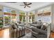 Spacious living room with large windows, comfortable seating, and a ceiling fan, offering serene views of the lake at 19040 Mary Ardrey Cir, Cornelius, NC 28031