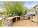Well-equipped outdoor kitchen with built-in grill and countertop space on a wooden deck at 19040 Mary Ardrey Cir, Cornelius, NC 28031