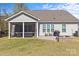 Cozy backyard featuring a screened porch, brick patio, grill, and charming stone fire pit at 2017 Autumn Dr, Monroe, NC 28110