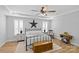 Spacious bedroom with decorative ceiling detail, modern ceiling fan, and plantation shutters at 2017 Autumn Dr, Monroe, NC 28110