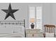 Bedroom with shuttered windows, bedside table and lamp, and a decorative metal star on the wall at 2017 Autumn Dr, Monroe, NC 28110